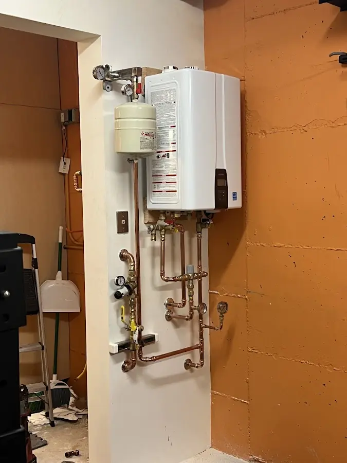 Plumbing technician inspecting water heater connections in Hiawatha